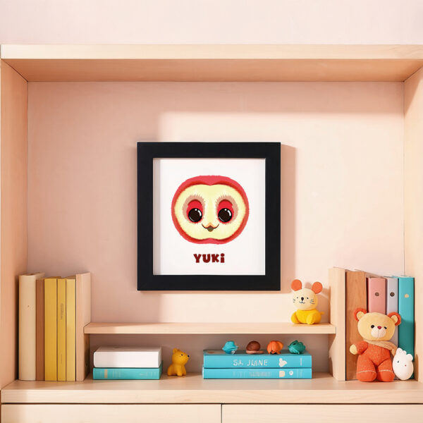 Illustration d’une chouette souriante et le prénom Yuki en dessous dans un cadre noir, posé dans une chambre d’enfant.
