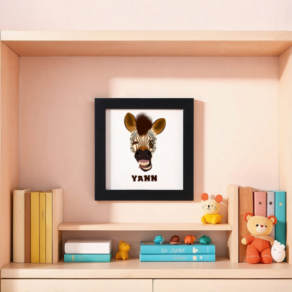 Illustration d’un zèbre faisant la grimace et le prénom Yann en dessous dans un cadre noir, posé dans une chambre d’enfant.